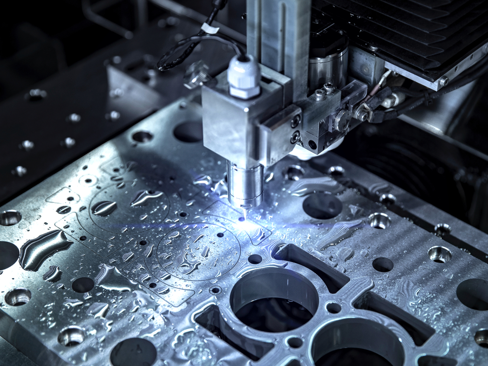 Робот для гидроабразивной резки вырезает сложные детали из алюминиевого листа толщиной около 1,5 дюймов.